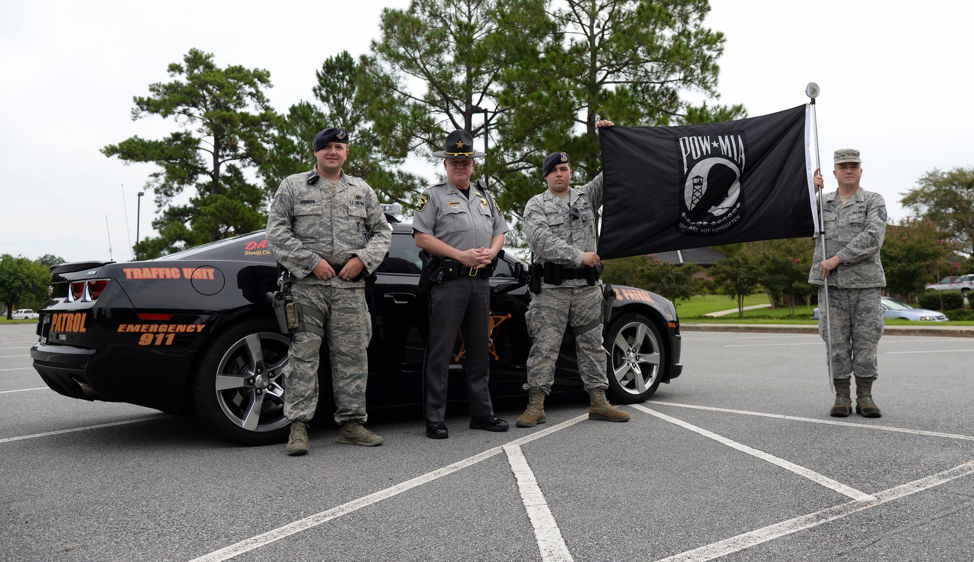 Members of the 23d Security Forces Squadron pose for a photo with police Lt. Mike Adams, Lowndes County sherrif deputy, Sept. 19, 2014, at Moody Air Force Base, Ga. Local police and base security forces escorted the runners during the 6th annual Tiger-thon run. (U.S. Air Force photo by Senior Airman Sandra Marrero/Released)
