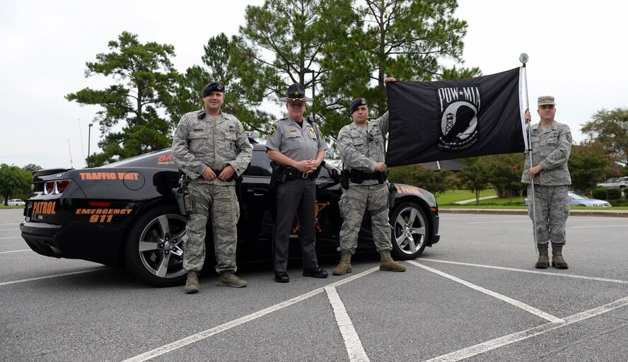 Members of the 23d Security Forces Squadron pose for a photo with police Lt. Mike Adams, Lowndes County sherrif deputy, Sept. 19, 2014, at Moody Air Force Base, Ga. Local police and base security forces escorted the runners during the 6th annual Tiger-thon run. (U.S. Air Force photo by Senior Airman Sandra Marrero/Released)
