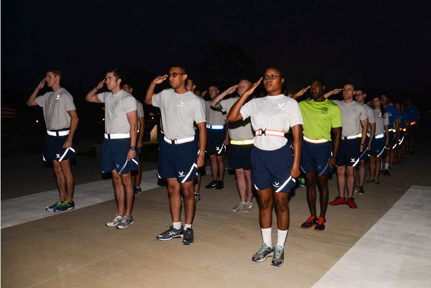 Airmen from the 23d Wing Staff Agencies and Comptroller Squadron render a salute as the national anthem plays Sept. 19, 2014, at Moody Air Force Base, Ga. The 23d WSA and CPTS kicked off this year’s Tiger-thon run by completing the first mile. (U.S. Air Force photo by Senior Airman Sandra Marrero/Released)
