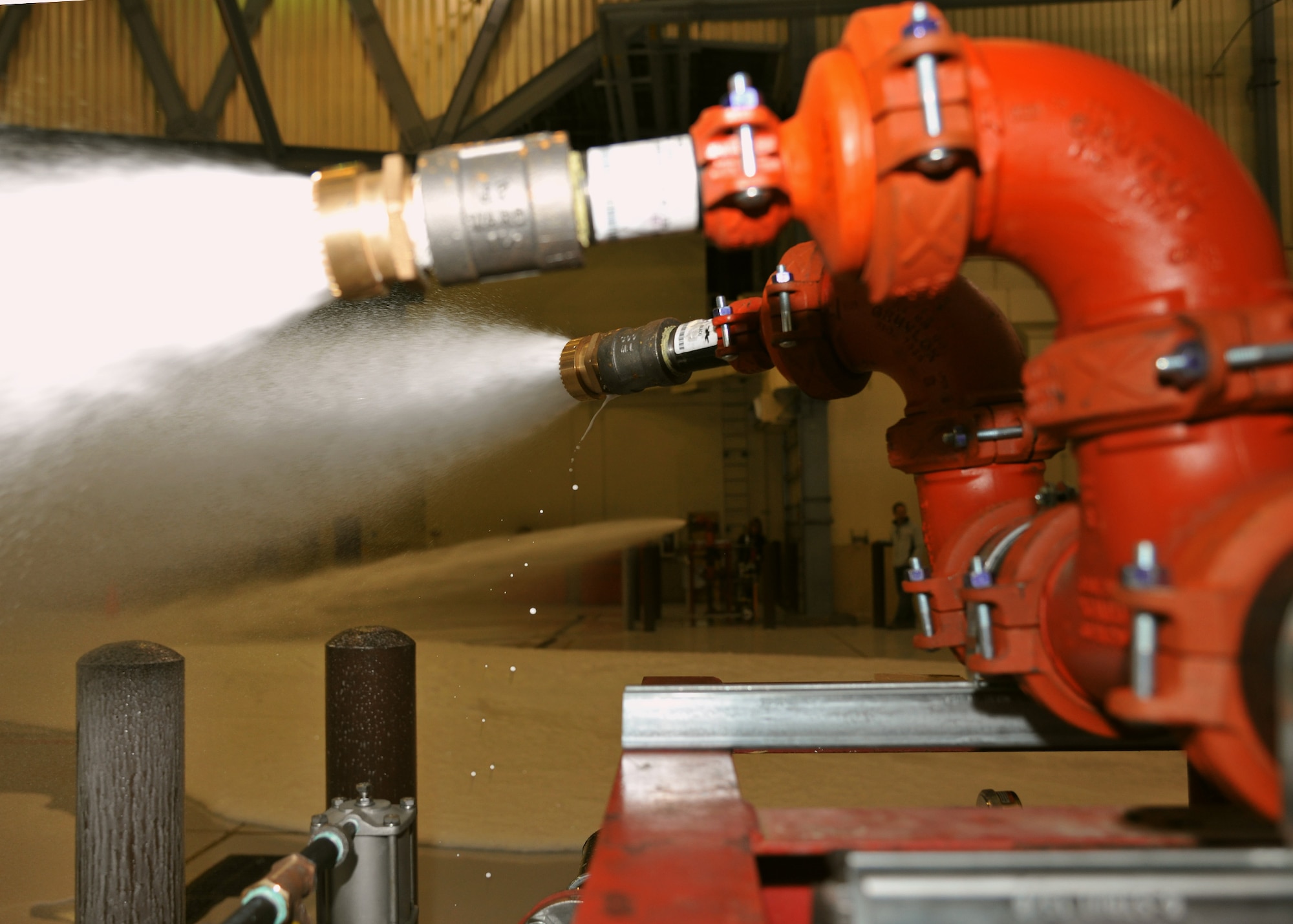 Fire suppression guns fire an aqueous film-forming foam in the 3-Bay hangar during a final test of the fire suppression system Sept. 23, 2014, on Grand Forks Air Force Base, N.D. The suppression guns spray 110 gallons of foam per square inch onto the floor of the hangar to protect an aircraft in the event of a fire. (U.S. Air Force photo/Senior Airman Xavier Navarro)