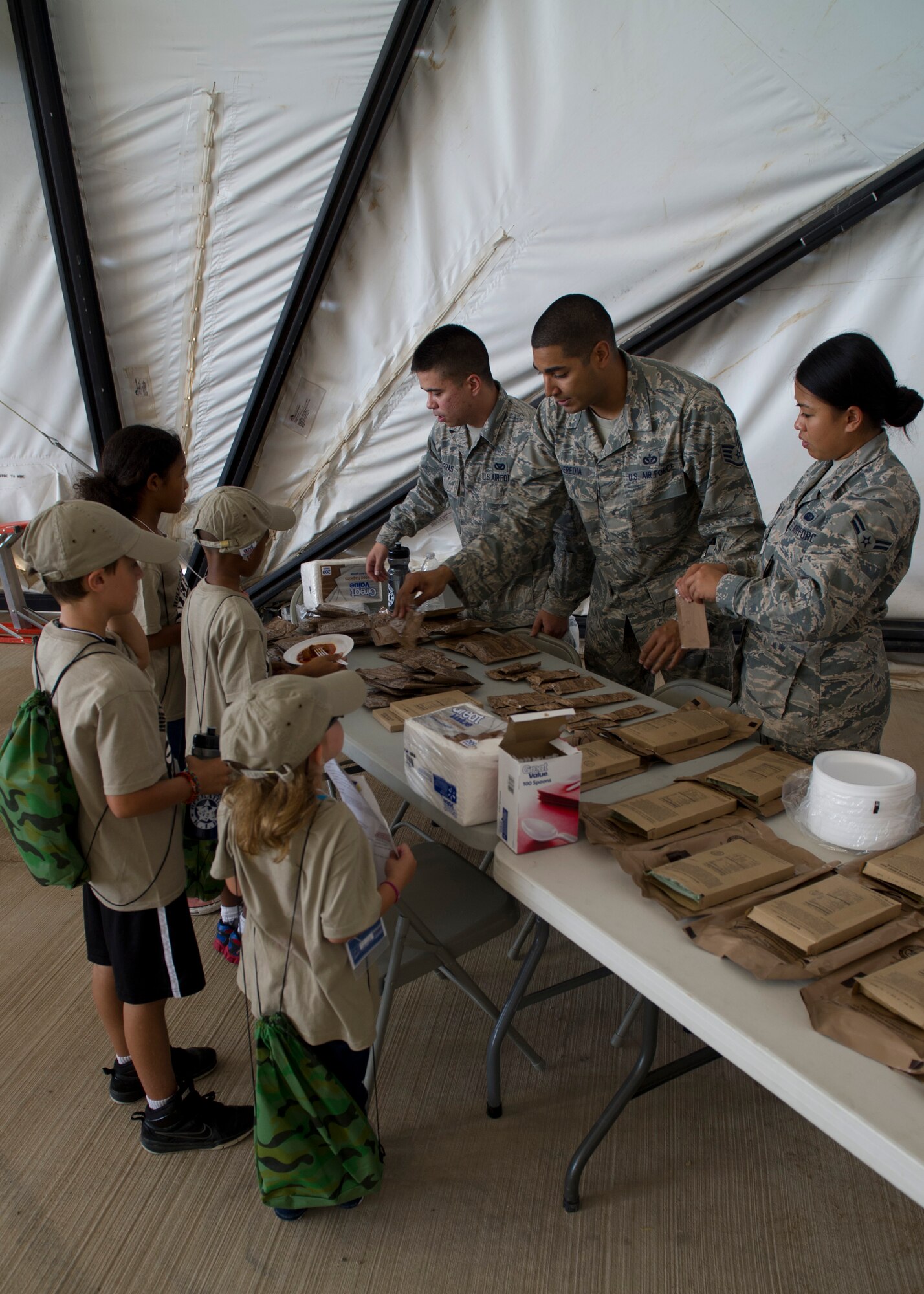 Team Holloman youth “deployers” walk through chalks and pick up a Meal-Ready-to-Eat during Operation Kids Investigating Deployment at Holloman Air Force Base N.M., Sept. 22. The kids got to eat and test the different kinds of MRE’s, seeing what food is like in some deployed locations. Operation K.I.D. is an event put on for military youth that teaches them the deployment process. Youth ages 5-13 go through a mock deployment at the 49th Materiel Maintenance Group and receive military orders, gear and a uniform. The children also learn about safety and the conditions of their mock destination. This annual event is held to give kids a better understanding on what it’s like when their loved ones prepare for deployment. (U.S. Air Force photo by Senior Airman Leah Ferrante/Released) 