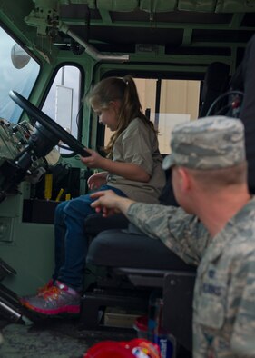Senior Airman Anthony Johnson, 49th Civil Engineer Squadron, Fire Protection Flight firefighter, explains the controls in the fire engine for a chalk walk during Operation Kids Investigating Deployment at Holloman Air Force Base N.M., Sept 22. Operation K.I.D. is an event put on for military youth that teaches them the deployment process. Youth ages 5-13 go through a mock deployment at the 49th Materiel Maintenance Group and receive military orders, gear and a uniform. The children also learn about safety and the conditions of their mock destination. This annual event is held to give kids a better understanding on what it’s like when their loved ones prepare for deployment. (U.S. Air Force photo by Senior Airman Leah Ferrante/Released) 