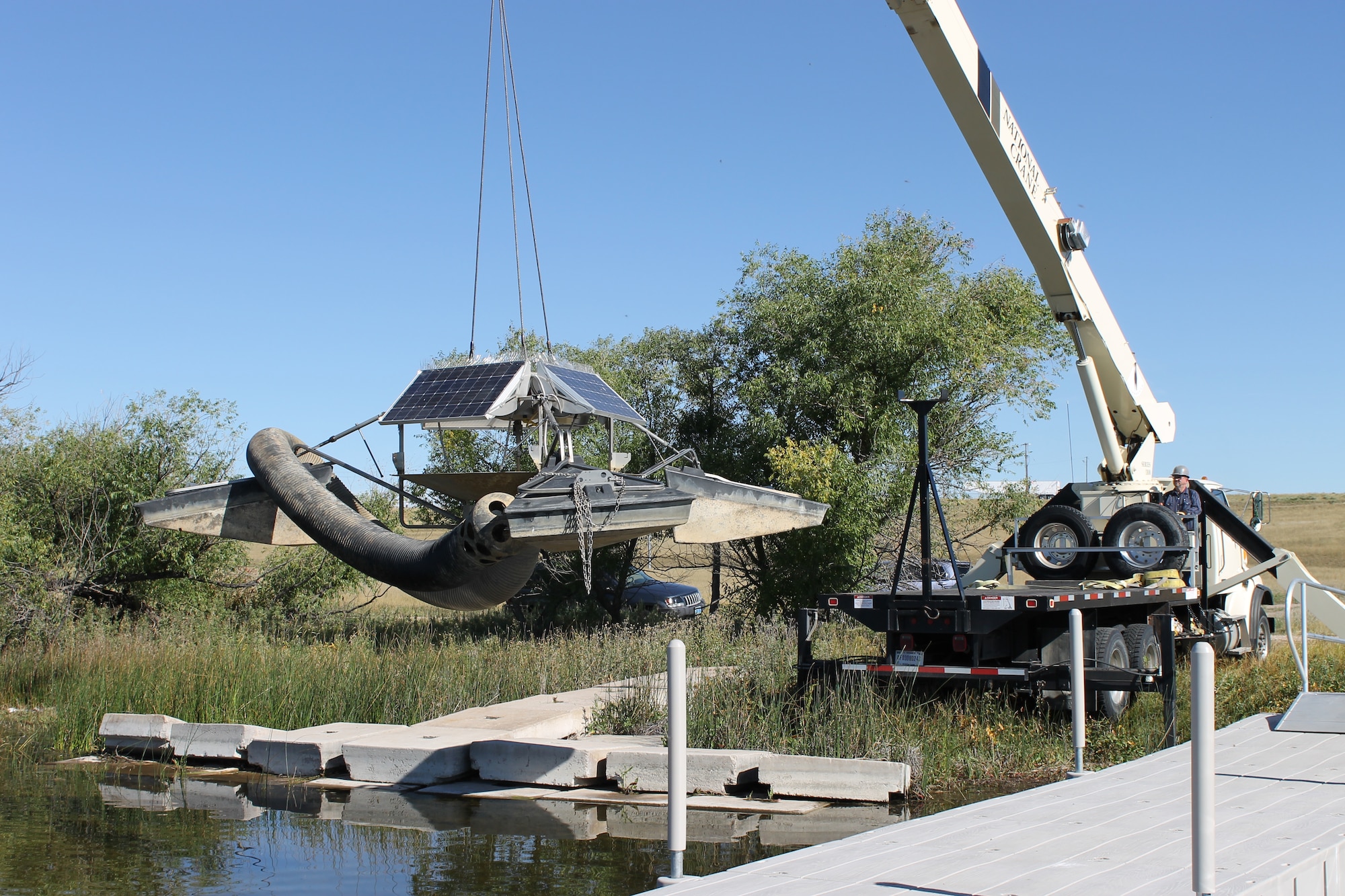 Robert Dunn, 90 Civil Engineer Squadron engineer equipment operator, installs a solar-powered water circulator, the SolarBee aerator, into North Lake Pearson on F.E. Warren Air Force Base, Wyo., Sept. 18, 2014. The circulator will help the fish habitat and also improve the quality of the water in North Lake Pearson due to constant movement of water. The lake will be stocked with trout in October, which will optimize the habitat for them. A base fishing license is required to fish in the lake and can be purchase at Outdoor Recreation, 773-2988. (Courtesy photo by Elizabeth McClain)