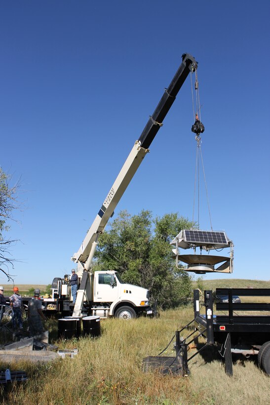 The 90th Civil Engineer Squadron installs a solar-powered water circulator, the SolarBee aerator, into North Lake Pearson on F.E. Warren Air Force Base, Wyo., utilizing a crane from Pavements and Equipment, a boat from Outdoor Recreation and personnel from P&E, Missile Facility Maintenance and the Environmental Element Sept. 18, 2014. The circulator was formally deployed at Buckley AFB, Colo., in Lake Williams, but was no longer needed when the lake was deemed a Bird Aircraft Strike Hazard. (Courtesy photo by Elizabeth McClain)