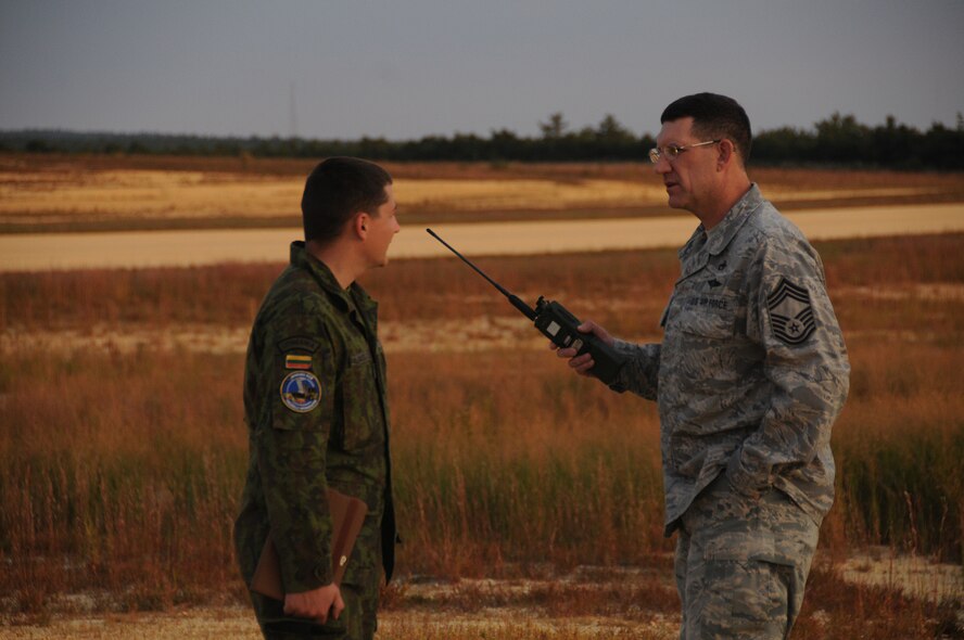 Lithuanian Air Force Capt. Simonas Paulauskas, left, listens to U.S. Air Force Chief Master Sgt. Edward Ratka, 193rd Special Operations Logistics Readiness Squadron aerial transportation superintendent, explain aerial drop procedures while waiting at Coyle Field Airport, Chatsworth, N.J. Sept. 18, 2014, for container delivery systems to be dropped from an EC-130J Hercules aircraft. As part of Pennsylvania-Lithuania National Guard State Partnership Program members of the LTAF and a member of the Latvian Air Force trained with 193rd SOLRS. (U.S. Air National Guard photo by Tech. Sgt. Culeen Shaffer/Released)