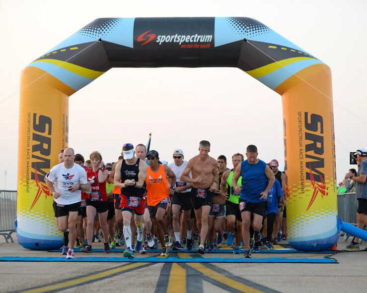 Participants of the Barksdale Half-Marathon and 5K begin their 3.2-mile or 13-mile trek on Barksdale Air Force Base, La., Sept. 20, 2014. Following the run, participants were given water and fruit to rehydrate and replenish electrolytes. (U.S. Air Force photo/Airman 1st Class Benjamin Raughton)