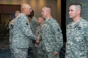 U.S. Army chief of staff Gen. Ray Odierno congratulates Sgt. 1st Class Kevin Johnson, Aviation Logistics Noncommissioned Officer Academy senior leader course senior small group leader, for receiving one of the first Army Instructor Badges, during a ceremony in Alexandria, Va., July 17, 2014. Johnson was one of seven Soldiers to receive the badges as part of a new Instructor Recognition and Development Program. (U.S. Army photo)