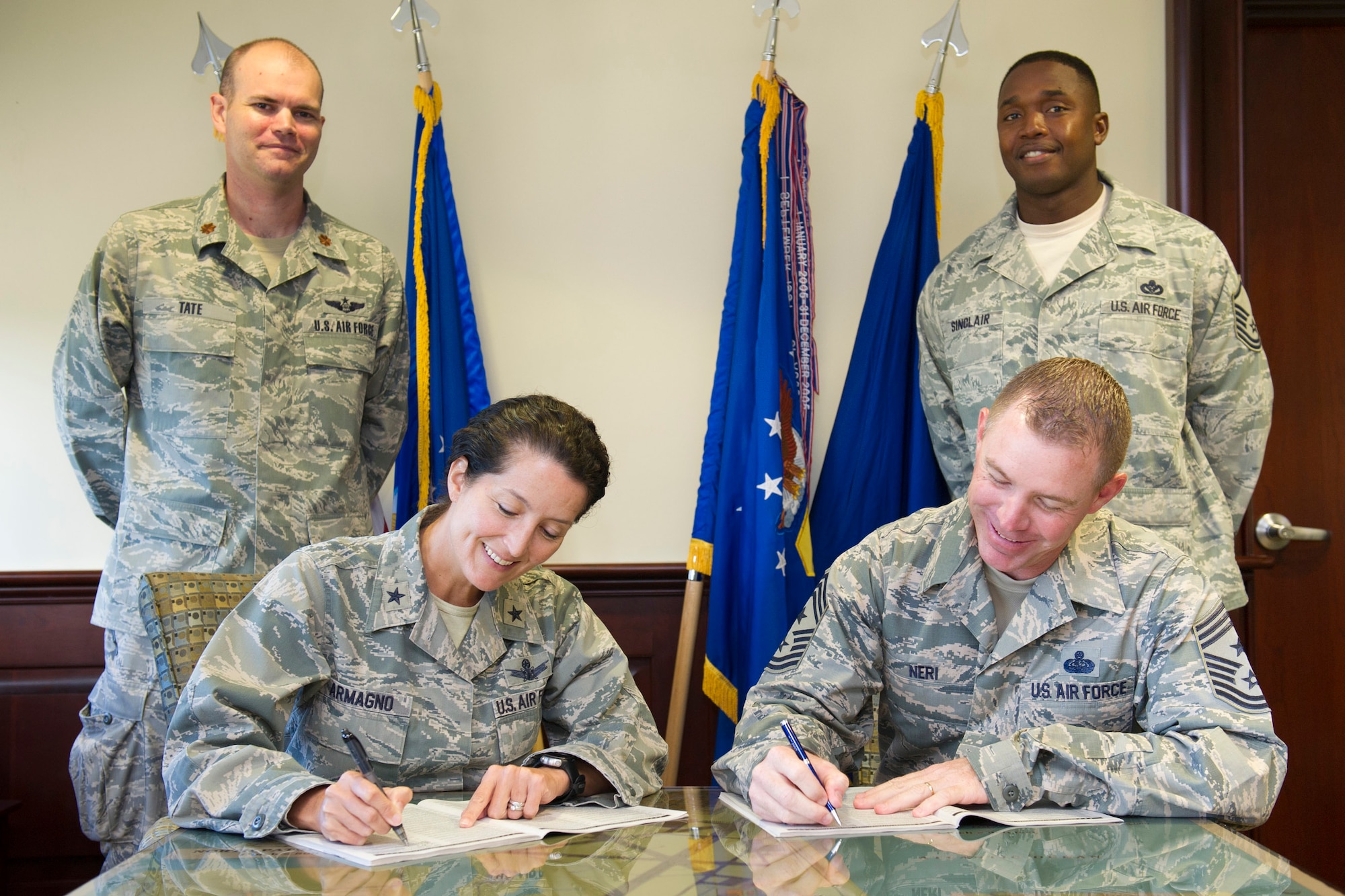 (Front left) Brig. Gen. Nina Armagno, 45th Space Wing commander, and (Front right) Chief Master Sgt. Craig Neri, 45th SW command chief, sign their Combined Federal Campaign donation forms, with the CFC representatives, Maj. Jason Tate (back left) and Master Sgt. Lee Sinclair, Sept. 15, 2014, at Patrick Air Force Base, Fla. Pledges can be made by military and civilian donors during the campaign season, which runs from Oct. 1-31. (U.S. Air Force photo/Matthew Jurgens (Released)