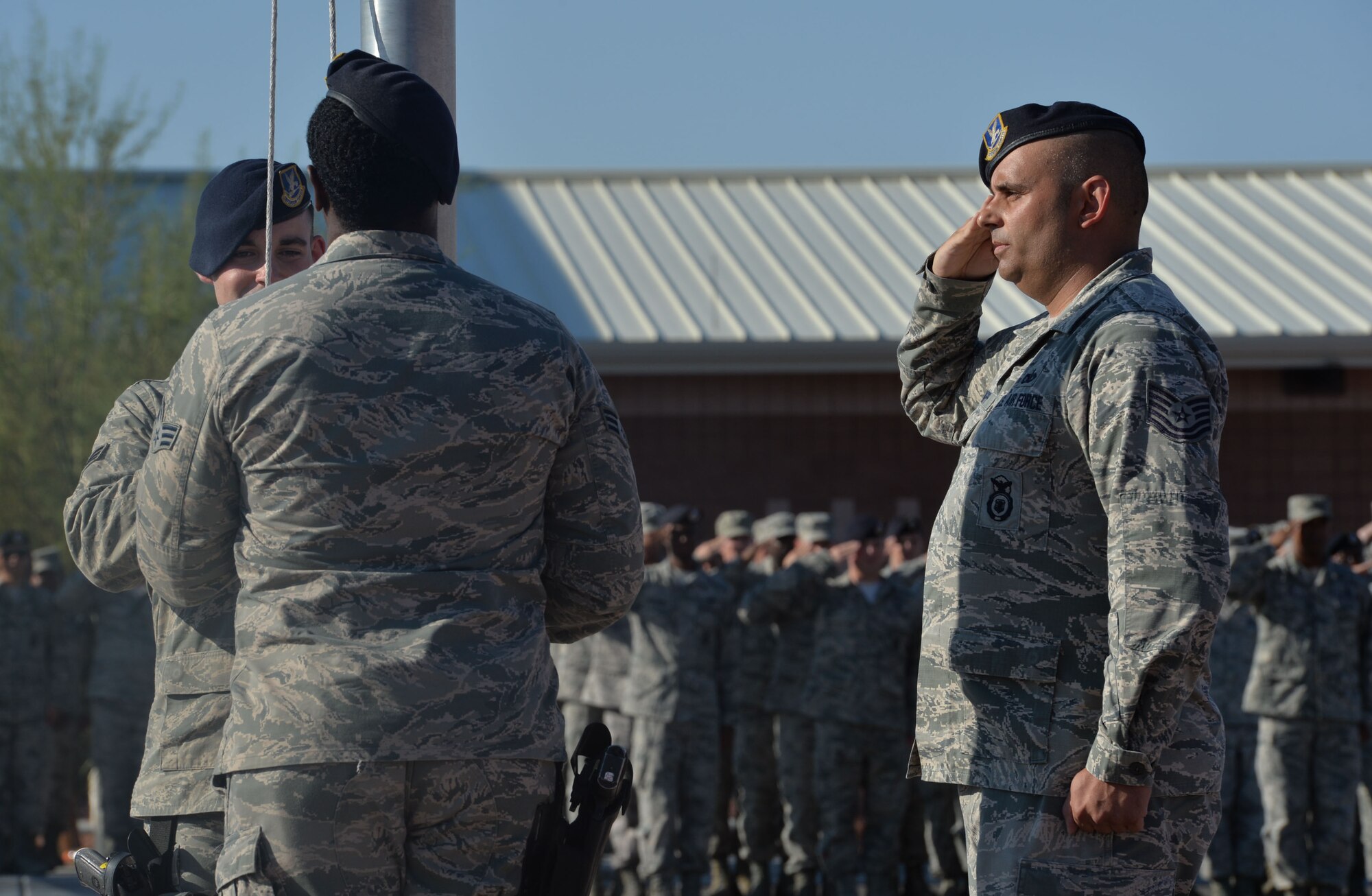 Airmen from the 799th Security Forces Squadron lower the flag during a formal retreat ceremony in remembrance of 9/11 at Creech Air Force Base, Nevada, Sept. 11, 2014. The event took place to honor those lost on Sept. 11, 2001, and those who have paid the ultimate sacrifice in the defense of our country. (U.S. Air Force photo by Tech. Sgt. Nadine Barclay/RELEASED)