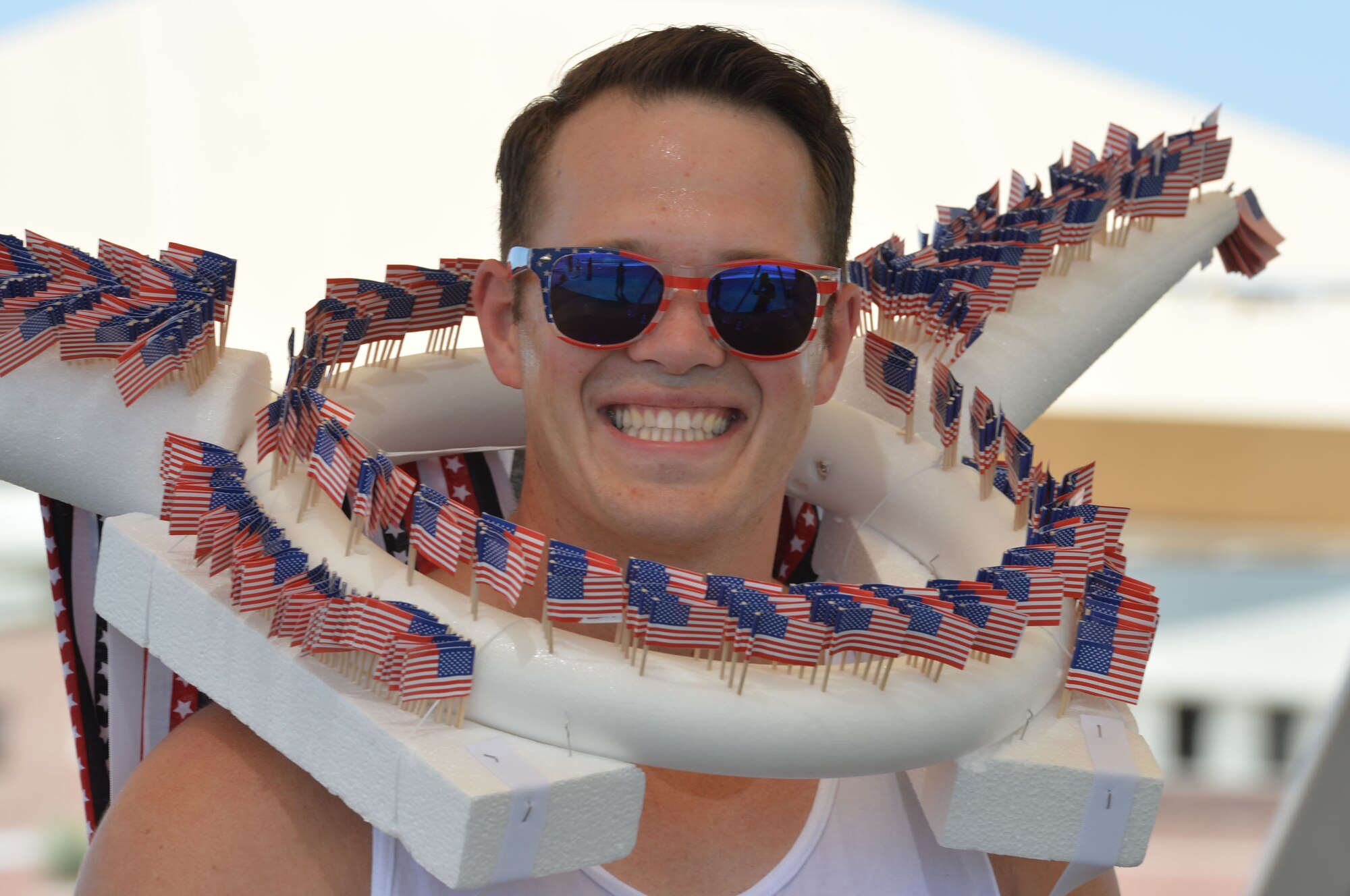 2nd Lt. Paul Baker, 432nd Maintenance Squadron maintenance flight officer-in-charge, displays his American pride while participating in the Team Red, White and Blue Coast-to-Coast relay race during the 9/11 remembrance event. Baker, who hand-made his costume, carried 500 miniature American flags in 100 degree weather to honor those lost on Sept. 11, 2001, and those who have paid the ultimate sacrifice in the defense of our country. (U.S. Air Force photo by Tech. Sgt. Nadine Barclay/RELEASED) 
