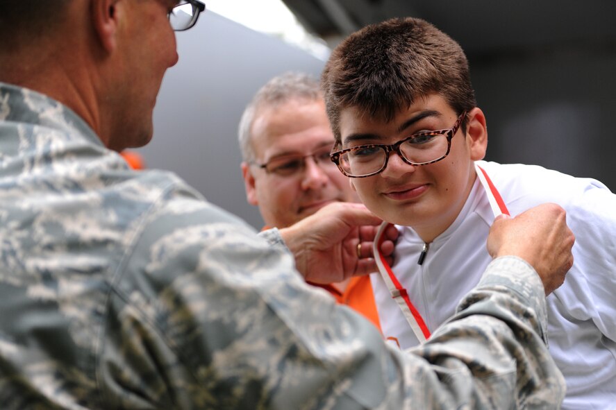 Col. Raymond Kozak, 512th Airlift Wing commander, presets Preston Buenaga with his gold medal during the Special Olympics of Delaware Cycling Competition awards ceremony Sept. 13, 2014 at Dover Air Force Base, Del. Buenaga took gold in the 500m competition. (U.S. Air Force photo/Staff Sgt. Elizabeth Morris)