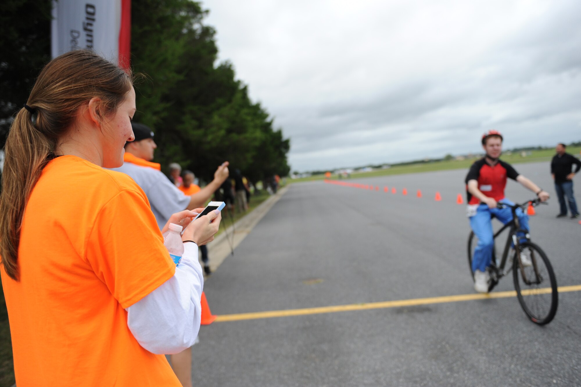 2nd Lt. Alannah Staver, 436th Airlift Wing Public Affairs deputy chief of public affairs, stops her timer as a Special Olympics athlete crosses the finish line during the Special Olympics of Delaware Cycling Competition Sept. 13, 2014 at Dover Air Force Base, Del. Staver and other Team Dover volunteers were assigned as time keepers for the races as well as cheerleaders for participants. (U.S. Air Force photo/Staff Sgt. Elizabeth Morris)