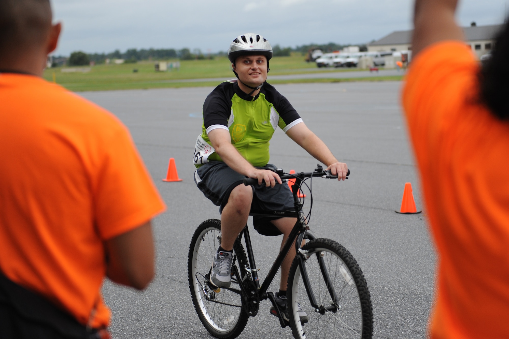 A Special Olympics of Delaware Cycling Competition athlete smiles as Team Dover volunteers cheer for him as he crosses the finish line Sept. 13, 2014 at Dover Air Force Base, Del. More than 150 volunteers from DAFB volunteered to help out at the event. (U.S. Air Force photo/Staff Sgt. Elizabeth Morris)