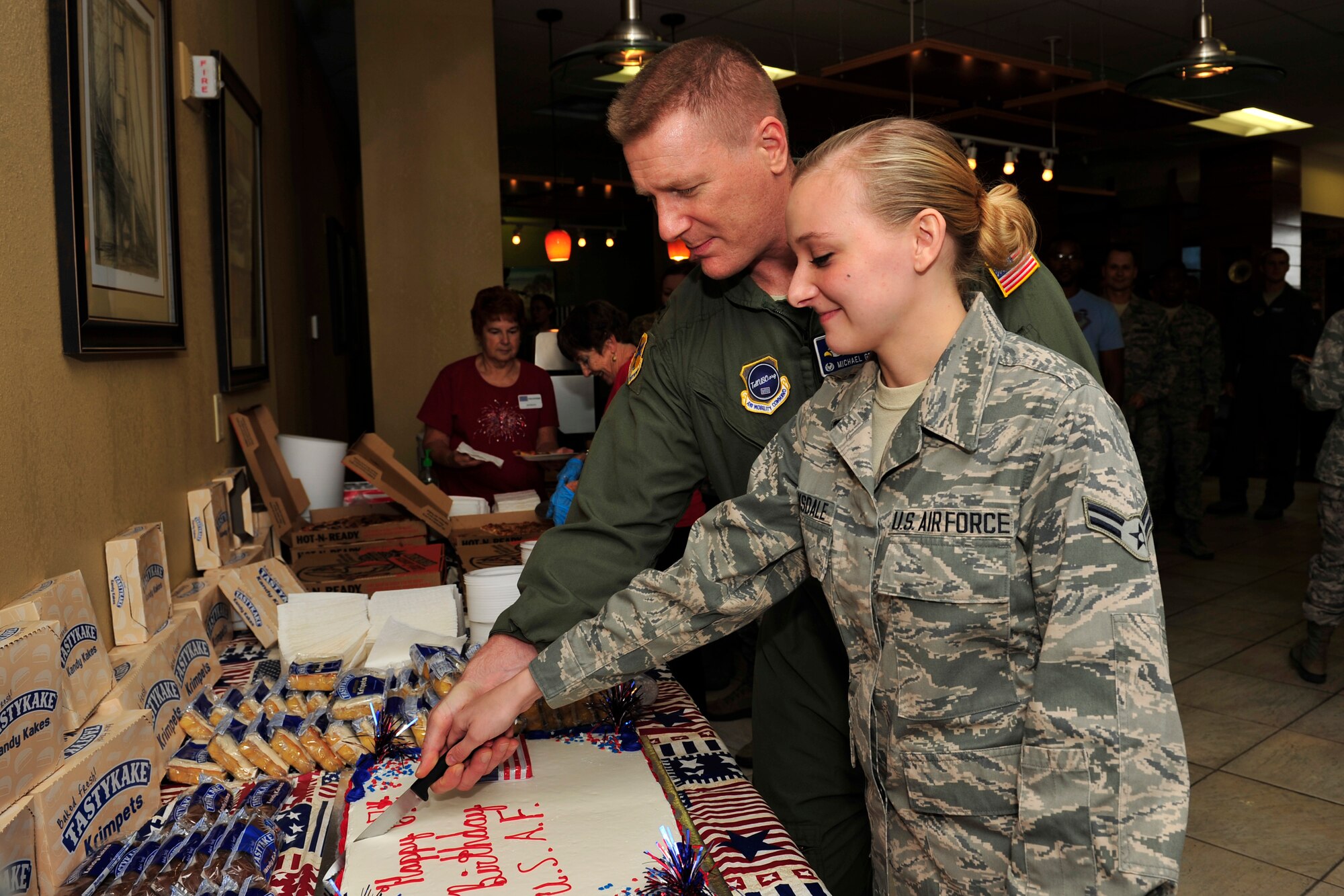 Col. Michael Grismer, Jr., 436th Airlift Wing commander, and Airman 1st Class Jennifer Barksdale, 9th Airlift Squadron commanders support staff, cut a cake during an Air Force birthday celebration at the USO lounge in the Passenger Terminal Sept. 18, 2014 on Dover Air Force Base, Del. Barksdale was selected to cut the cake with the commander because she was the most junior Airmen at the event. (U.S. Air Force photo/Staff Sgt. Elizabeth Morris)