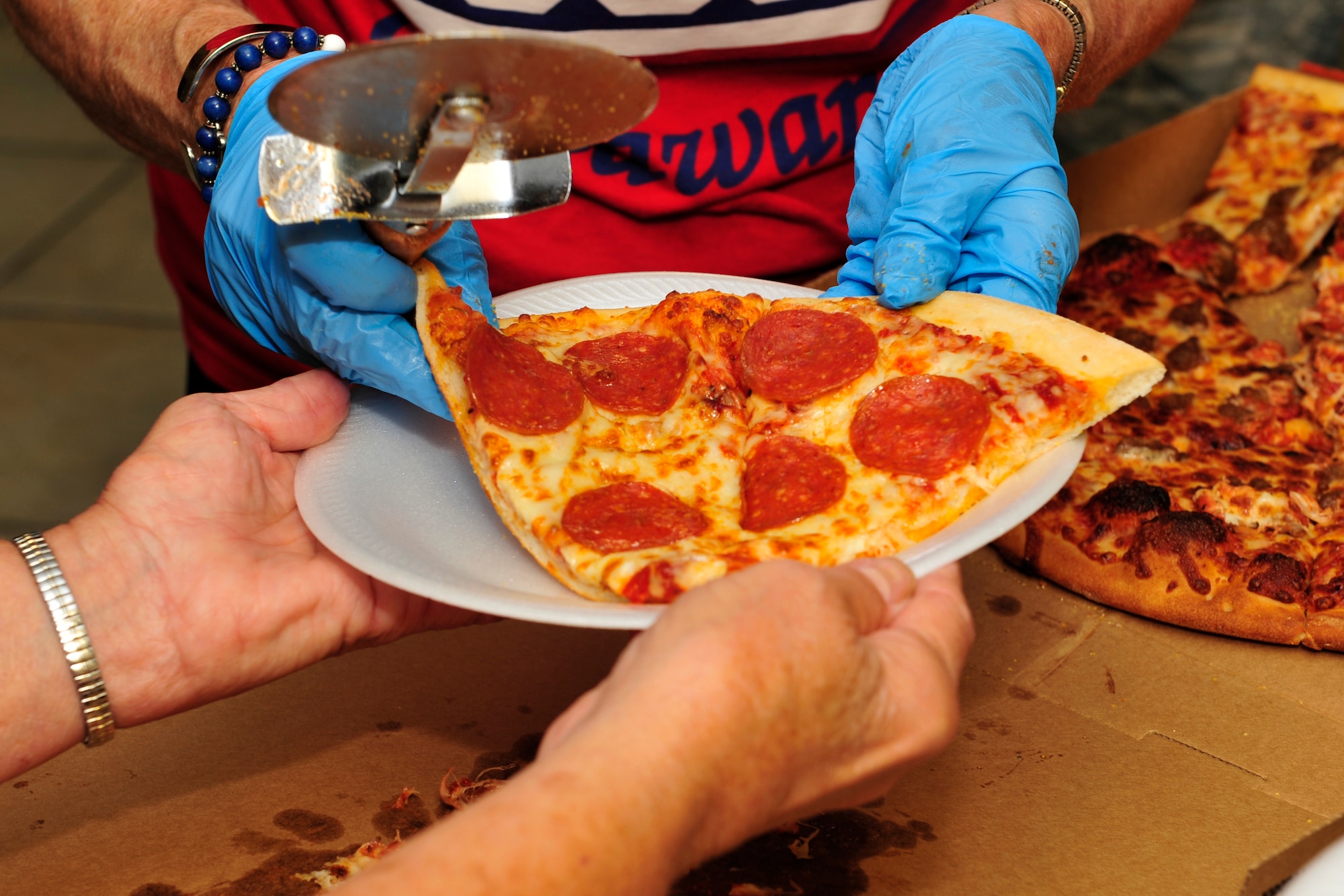 USO volunteers serve pizza to Team Dover members during the Air Force's 67th Birthday celebration Sept. 18, 2014 at the USO lounge on Dover Air Force Base, Del. The event was paid for by a national sponsor of the USO. (U.S. Air Force photo/Staff Sgt. Elizabeth Morris)
