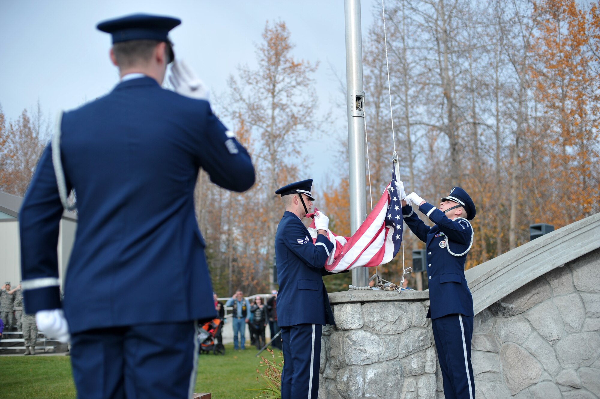 Eielson Air Force Base honor guard members retire the American flag for the day during a POW/MIA memorial ceremony Sept. 19, 2014, at Eielson AFB, Alaska. The POW/MIA memorial commemorates the men and women of the armed forces who have given immense sacrifices while in military service. (U.S. Air Force photo by Staff Sgt. Jim Araos/Released)