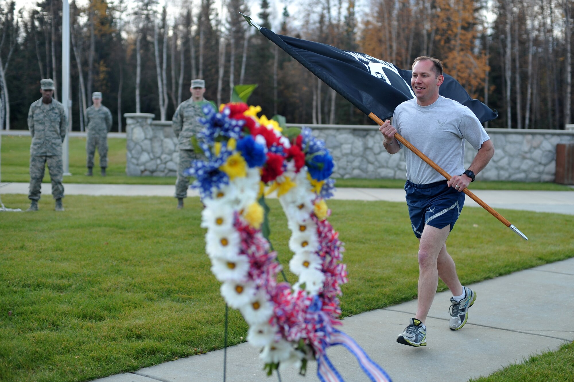 U.S. Air Force Master Sgt. Jerome Vahalik, 354th Security Forces Squadron, carries a POW/MIA flag during a 24-hour vigil run Sept. 19, 2014, at Eielson Air Force Base, Alaska. The flag remained in constant motion, passed from one group of runners to another, in a run dedicated to American prisoners of war and those missing in action. (U.S. Air Force photo by Staff Sgt. Jim Araos/Released)