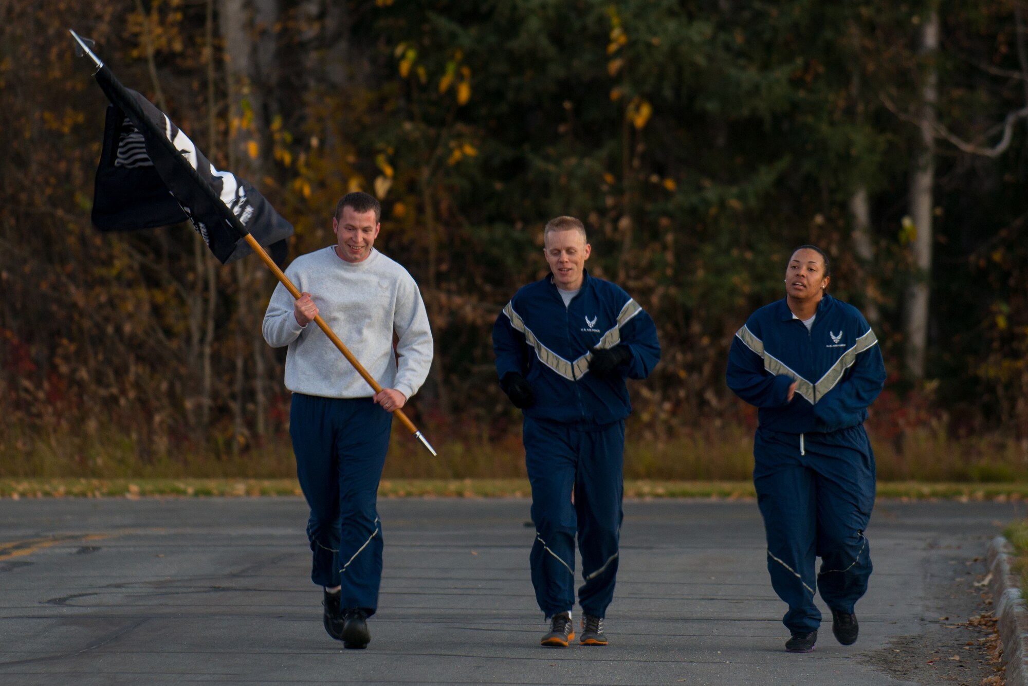 U.S. Air Force Tech. Sgt. Richard Gravely (left), Maj. Philip Broyles (center), and  Senior Airman Martina Mizell, all assigned to the 354th Maintenance Squardon, participate in a POW/MIA 24-hour vigil run during National POW/MIA Recognition Day at Eielson Air Force Base, Alaska, Sept. 19, 2014.  The third Friday of September each year is observed across the United States as National POW/MIA Recognition Day to honor prisoners of war and the missing as well as their families and highlights the government's commitment to account for them. (U.S. Air Force photo by Tech. Sgt. Joseph Swafford/Released)