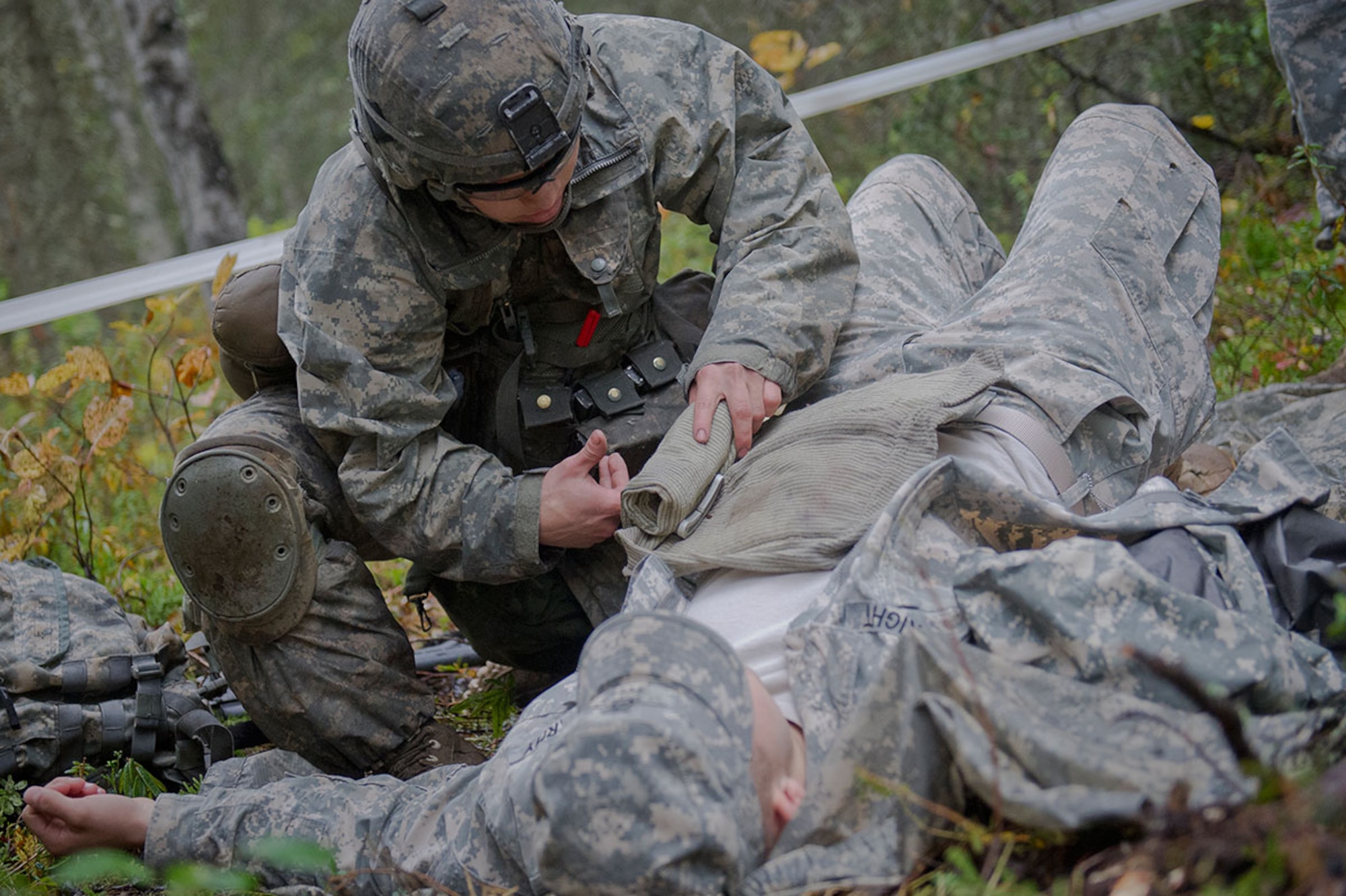 Army Spc. Luis Garcia, a native of Phoenix, Ariz., assigned to Commanche Company, 1st Battalion (Airborne), 501st Infantry Regiment, 4th Infantry Brigade Combat Team (Airborne), 25th Infantry Division, U.S. Army Alaska, performs buddy aid for a simulated casualty on an Expert Infantryman Badge qualification lane on Joint Base Elmendorf-Richardson, Wednesday, Sept. 10, 2014. The Expert Infantryman Badge was approved by the Secretary of War on October 7, 1943, and is currently awarded to U.S. Army personnel who hold infantry or special forces military occupational specialties and successfully pass the rigors of the course. (U.S. Air Force photo/Justin Connaher)