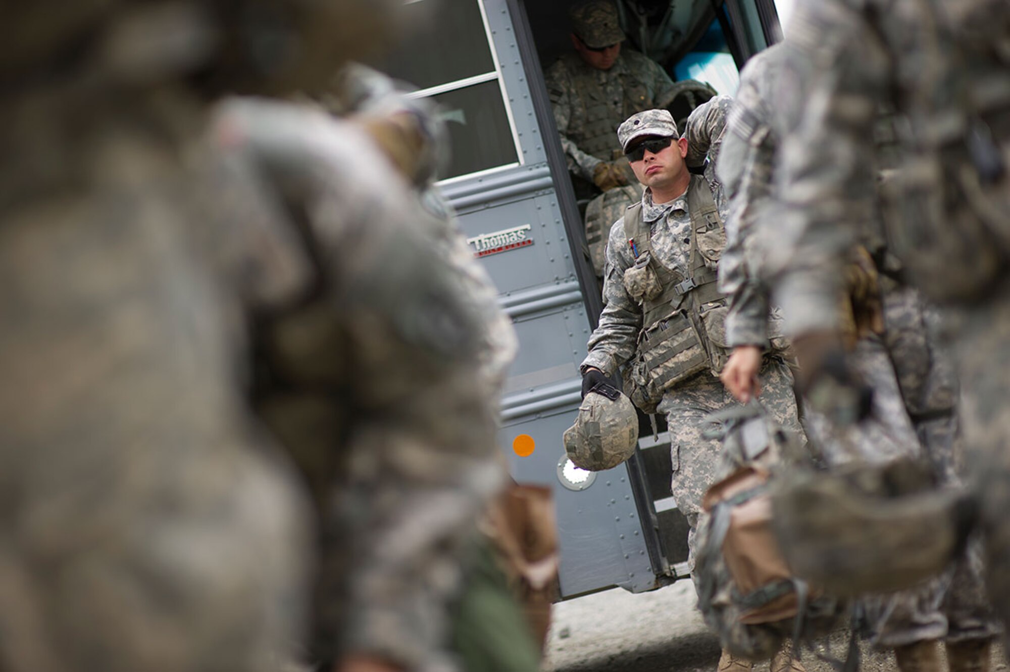 Spc. Kyle Navarre, a native of Detroit, assigned to Alpha Troop, 1st Squadron (Airborne), 40th Cavalry Regiment, 4th Infantry Brigade Combat Team (Airborne), 25th Infantry Division, U.S. Army Alaska, steps off a bus as he arrives at a staging area with fellow Soldiers during Expert Infantryman Badge qualification on Joint Base Elmendorf-Richardson, Tuesday, Sept. 9, 2014. The Expert Infantryman Badge was approved by the Secretary of War on October 7, 1943, and is currently awarded to U.S. Army personnel who hold infantry or special forces military occupational specialties and successfully pass the rigors of the course. (U.S. Air Force photo/Justin Connaher)