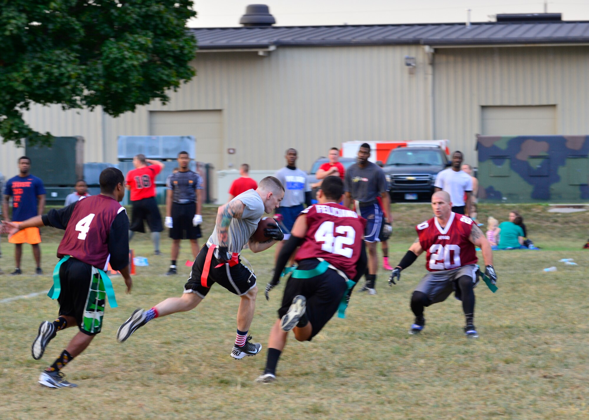 The Air Force Mortuary Affairs Operations defense swarms Henry Maurer, 436th Logistics Readiness Squadron wide receiver, after he catches a pass during a flag football game Sept. 18, 2014, at Dover Air Force Base, Del. Maurer caught the first touchdown pass of the game from 436th LRS quarterback, Jake Holst. (U.S. Air Force photo/Airman 1st Class William Johnson)