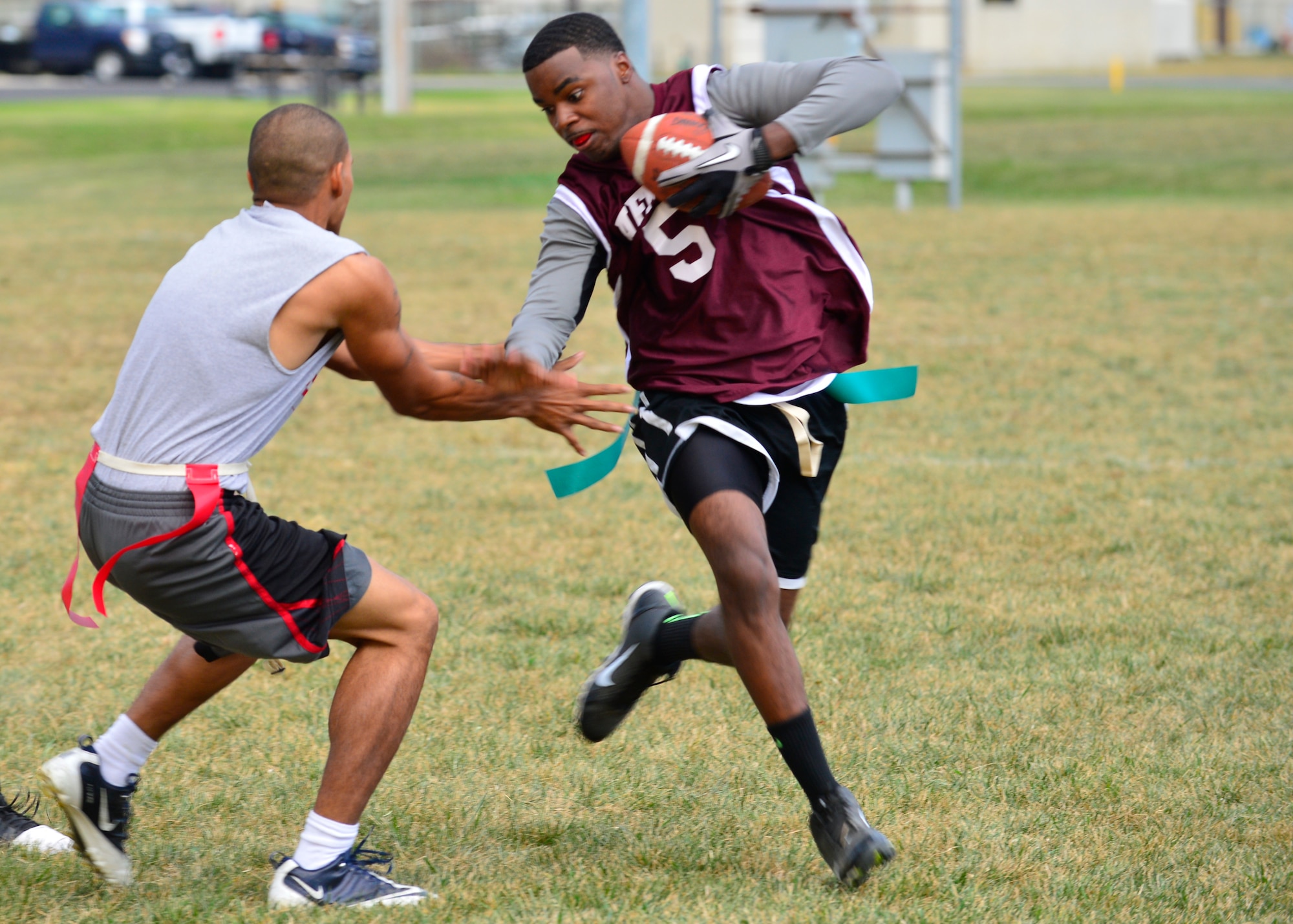Nicholas Williams, Air Force Mortuary Affairs Operations quarterback/running back, avoids Brandon Frank, 436th Logistics Readiness Squadron defensive back, from pulling his flag during flag football Sept. 18, 2014, at Dover Air Force Base, Del. The 436th LRS shut out AFMAO 13-0 to pick up their first win of the season. (U.S. Air Force photo/Airman 1st Class William Johnson)