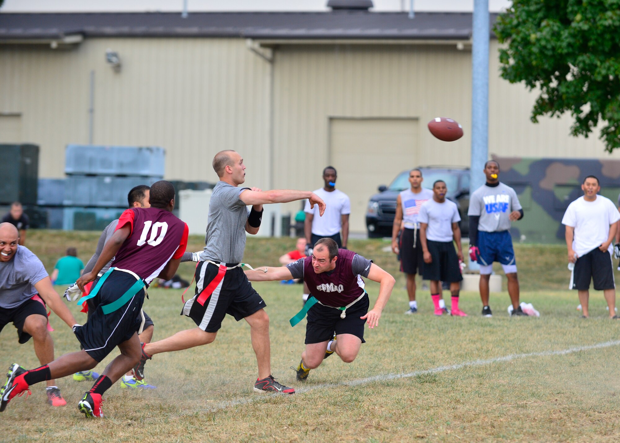 Jake Holst, 436th Logistics Readiness Squadron quarterback, completes a pass while being pressured from the Air Force Mortuary Affairs Operations defense during flag football Sept. 18, 2014, at Dover Air Force Base, Del. Holst threw two touchdown passes that led to the 13-0 victory against AFMAO. (U.S. Air Force photo/Airman 1st Class William Johnson)