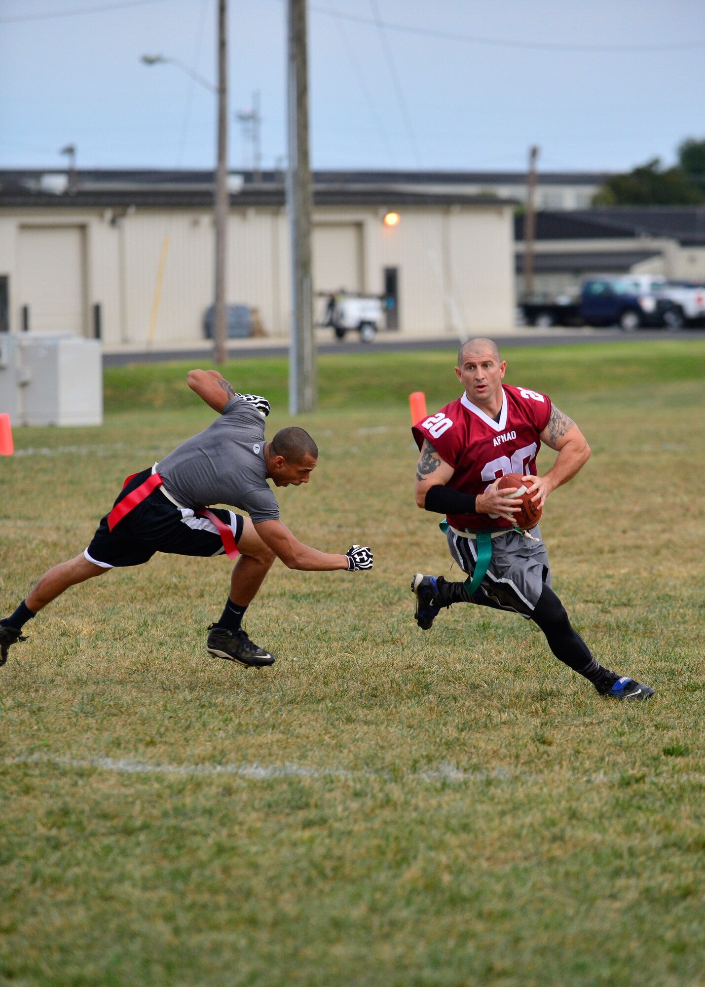 Brian Denny, Air Force Mortuary Affairs Operations quarterback, avoids a sack from Brandon Clayton, 436th Logistics Readiness Squadron defensive lineman, during flag football Sept. 18, 2014, at Dover Air Force Base, Del. The 436th LRS defeated AFMAO 13-0. (U.S. Air Force photo/Airman 1st Class William Johnson)