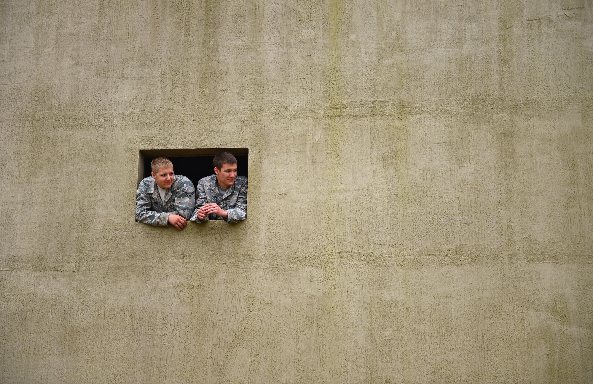 Airmen from the 48th Mission Support Group watch a training exercise from a building constructed as a mock village during a force-on-force exercise at Stanford Training Area, England, Sept. 19, 2014. More than 130 48th MSG Airmen participated in the training exercises and practiced scenarios they could possibly encounter in a deployed environment. (U.S. Air Force photo by Airman 1st Class Erin O’Shea/Released) 