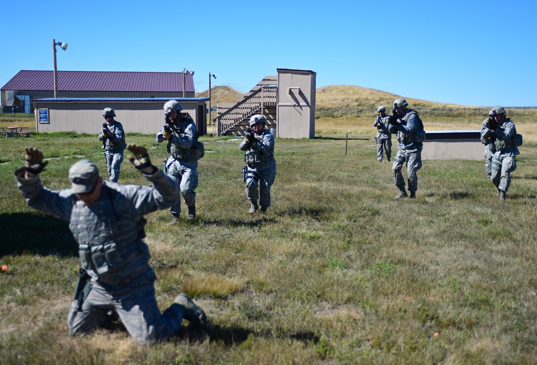 Airmen assigned to the 28th Security Forces Squadron simulate taking a hostile hostage during small unit tactics training at Ellsworth Air Force Base, S.D., Sept. 12, 2014 during an Operational Readiness Exercise. The training was a key part of the ORE meant to test the base’s abilities to react and respond to threats in a contingency environment. (U.S. Air Force photo by Senior Airman Zachary Hada/Released)