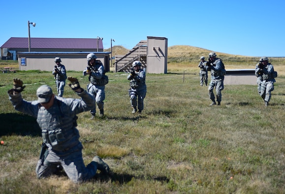 Airmen assigned to the 28th Security Forces Squadron simulate taking a hostile hostage during small unit tactics training at Ellsworth Air Force Base, S.D., Sept. 12, 2014 during an Operational Readiness Exercise. The training was a key part of the ORE meant to test the base’s abilities to react and respond to threats in a contingency environment. (U.S. Air Force photo by Senior Airman Zachary Hada/Released)