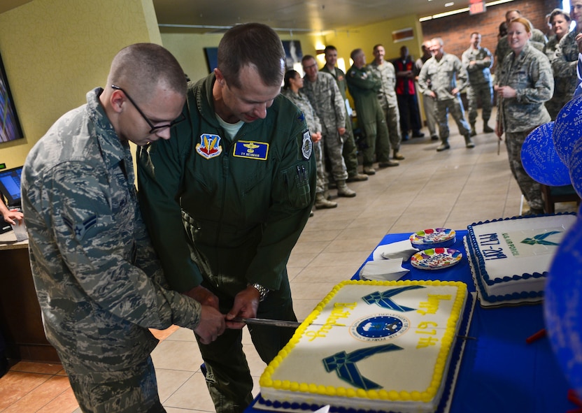 Col. Ty Neuman, 28th Bomb Wing vice commander, and the youngest Airman on base Airman 1st Class Evan Meija, 37th Aircraft Maintenance Unit crew chief, cut a birthday cake during a celebration in honor of the Air Force’s 67th birthday in the Raider Café at Ellsworth Air Force Base, S.D., Sept. 18, 2014. The cake-cutting tradition symbolizes the passing down of wisdom from senior to junior servicemembers, a key element of Air Force heritage. (U.S. Air Force photo by Senior Airman Zachary Hada/Released)