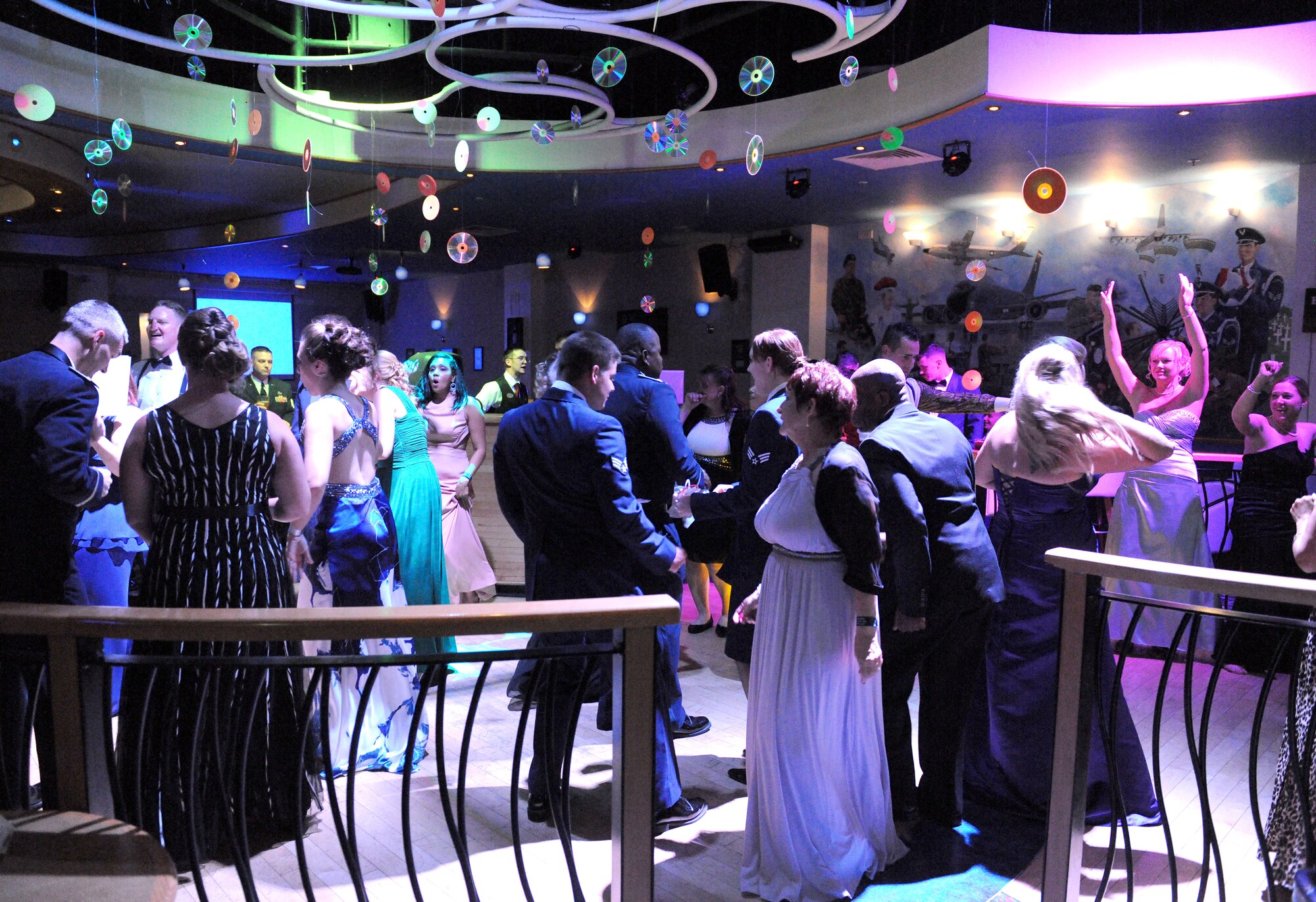 Team Mildenhall members and their dates dance to ‘90’s music at the Air Force Ball Sept. 20, 2014, on RAF Mildenhall, England. The ‘90’s themed event titled “Saved by the Ball” celebrated the Air Force’s 67th birthday as an independent service with fact filled paper fortune tellers, glow sticks, CDs, slap bracelets, ‘90’s music including a ‘90’s cover band, grunge-dressed food servers and two Airmen that helped coordinate the event even wore their outdated battle dress uniforms. (U.S. Air Force photo/Senior Airman Kate Maurer/Released)