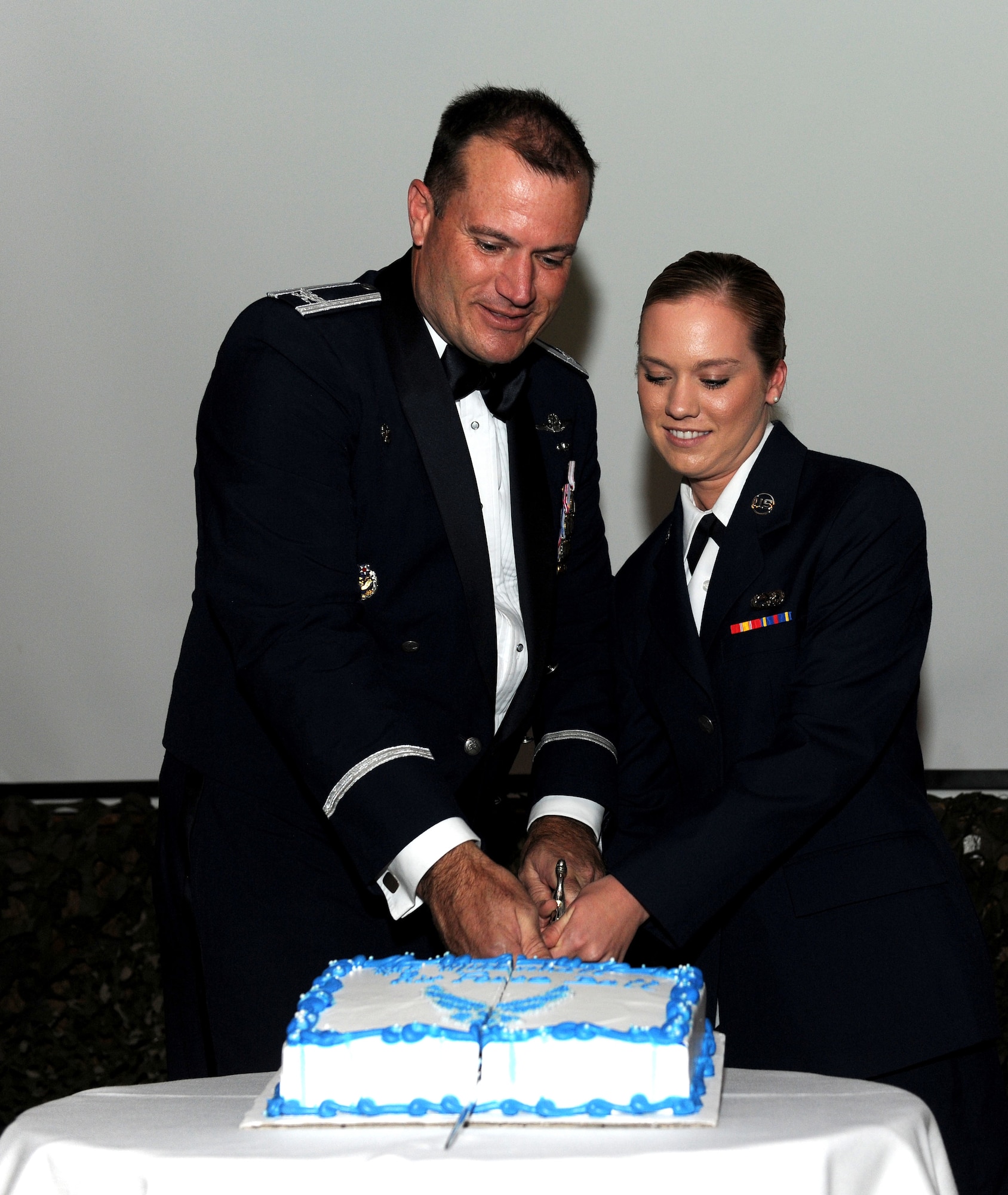 U.S. Air Force Col. Kenneth T. Bibb Jr., left, 100th Air Refueling Wing commander, and U.S. Air Force Airman Basic Heather Graham, 100th Logistics Readiness Squadron vehicle operator from Santa Fe, Texas, cut a cake using a saber at the Air Force Ball Sept. 20, 2014, on RAF Mildenhall, England. The event celebrated the Air Force's 67 years as an independent service. (U.S. Air Force photo/Senior Airman Kate Maurer/Released)