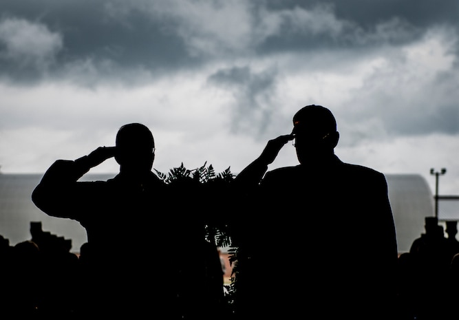 Col. Jeffrey DeVore, Joint Base Charleston commander, and former Prisoner of War, salute a Prisoner of War, Missing in Action wreath during a retreat ceremony Sept. 19, 2014, at Joint Base Charleston, S.C. The ceremony was held in honor of prisoners of war, service members still missing in action and family members who share in the sacrifices of freedom. (U.S. Air Force photo/ Senior Airman Dennis Sloan)