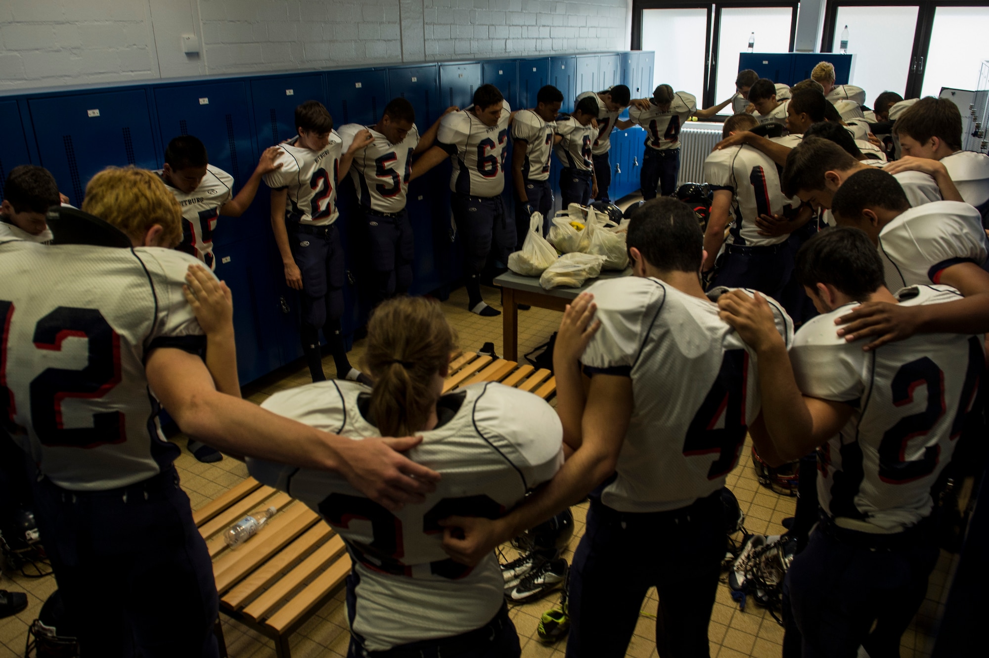 The Bitburg Barons football team prays in a circle prior to the start of their game against the Ansbach Cougars Sept. 20, 2014, at Ansbach, Germany. This was the third regular season game for the Barons. (U.S. Air Force photo by Senior Airman Rusty Frank/Released)