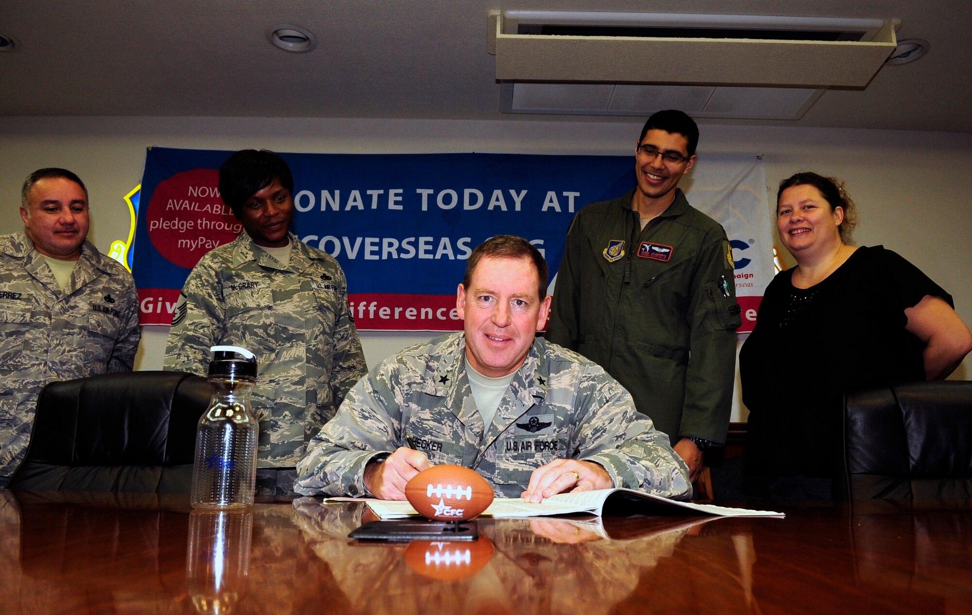 U.S. Air Force Brig. Gen. James Hecker, 18th Wing commander, fills out a 2014 pledge card during the Combined Federal Campaign-Overseas season on Kadena Air Base, Japan, Sept. 23, 2014. Beginning Sept. 8 and ending on Nov. 7, 2014, the CFC-O is an annual workplace campaign for the unified combatant commands. As of Sept. 22, Kadena has pledged more than $27,000 toward the CFC-O, ranking 1st in the Pacific Command CFC-O thus far. (U.S. Air Force photo by Airmen 1st Class Keith James/Released)