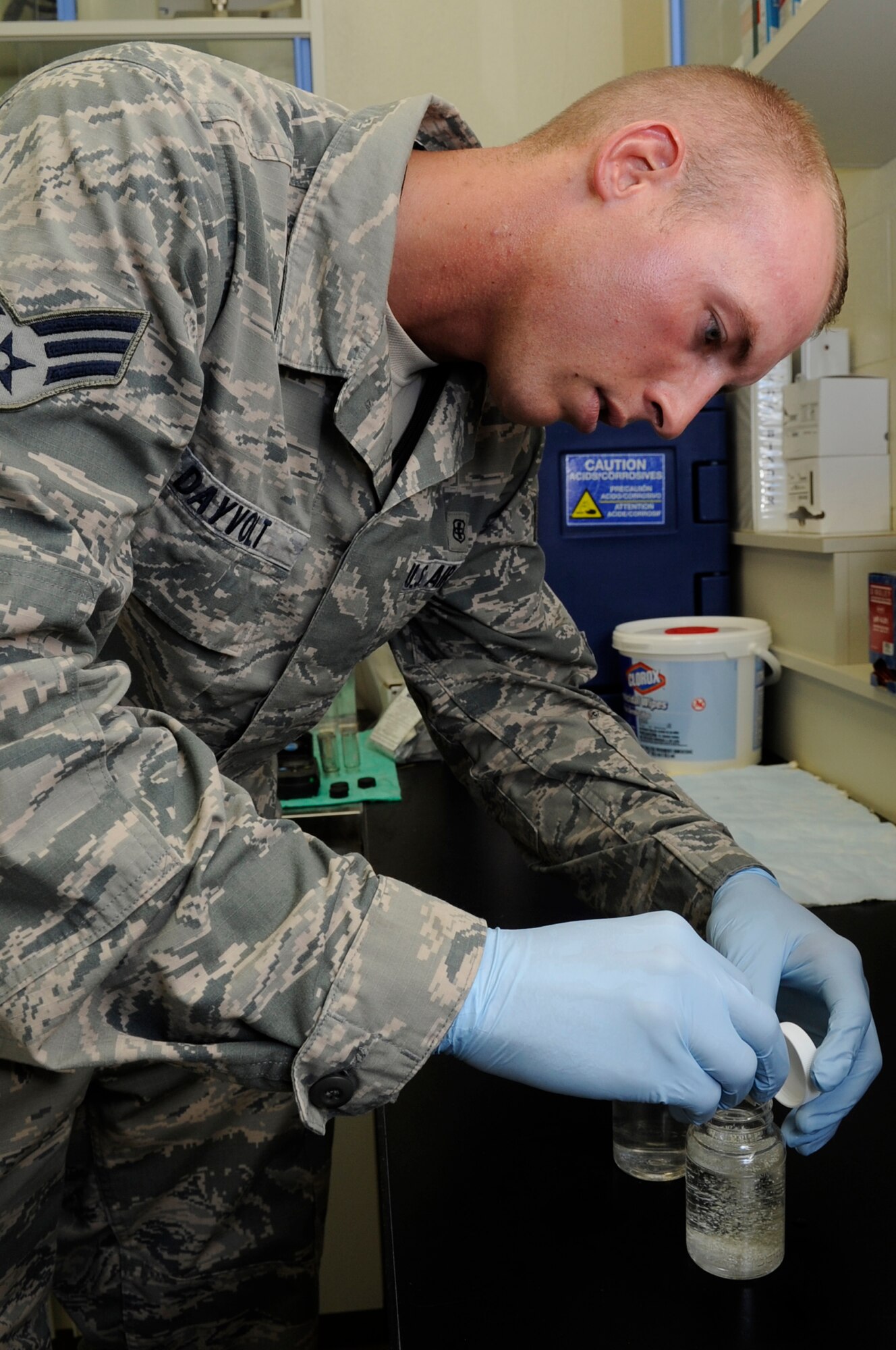 U.S. Air Force Senior Airman Dustin Dayvolt, 18th Aerospace Medicine Squadron bioenvironmental engineering technician, adds colilert to a test blank and a test sample on Kadena Air Base, Japan, Sept. 23, 2014. Colilert allows the technicians to determine if E. coli is present in the water after letting it incubate for 24 hours. (U.S. Air Force photo by Senior Airman Marcus Morris/Released)