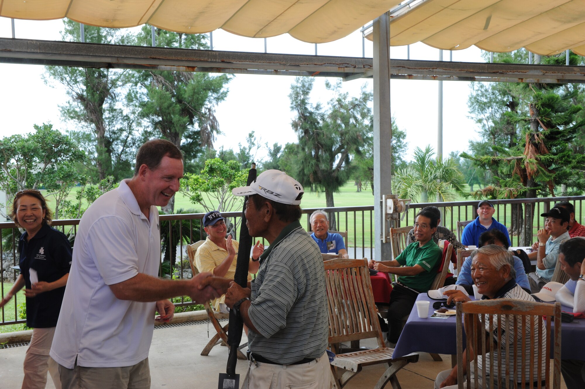 U.S. Air Force Brig. Gen. James Hecker, 18th Wing commander, presents Kunio Kudaka, honorary commander and former Master Labor Contractor for more than 40 years, with a new Nike umbrella for winning the door prize at the Friendship golf tournament on Kadena Air Base, Japan, Sept. 23, 2014. The Friendship golf tournament was open to local businessmen and honorary commanders to come play golf and have lunch with members of Team Kadena. (U.S. Air Force photo by Airmen 1st Class Stephen G. Eigel)