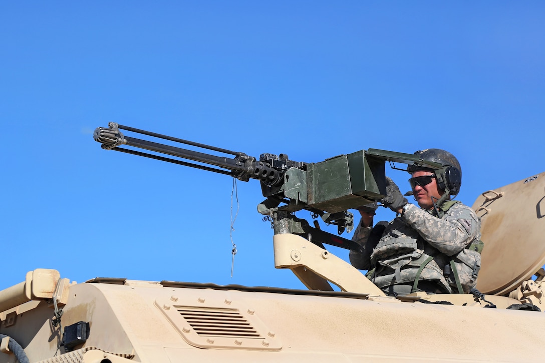 A soldier fires a machine gun from a tactical vehicle after contact during Decisive Action Rotation 14-10 at the National Training Center on Fort Irwin, Calif., Sept. 13, 2014. The soldiers are assigned to 2nd Battalion 29th Field Artillery Regiment.