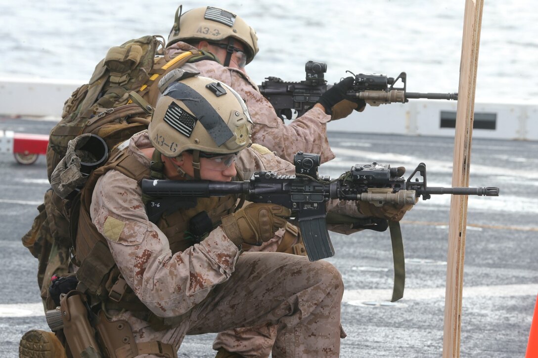 U.S. Marines with the Force Reconnaissance detachment, 11th Marine Expeditionary Unit (MEU), fire their M4 carbines from behind cover during a close-quarters tactics and movement live-fire range on the flight deck of the amphibious transport dock ship USS San Diego (LPD 22) while underway.  San Diego is part of the Makin Island Amphibious Ready Group and, with the embarked 11th MEU, is deployed in support of maritime security operations and theater security cooperation efforts in the U.S. 5th Fleet area of responsibility. (U.S. Marine Corps photo by Cpl. Jonathan R. Waldman/Released)