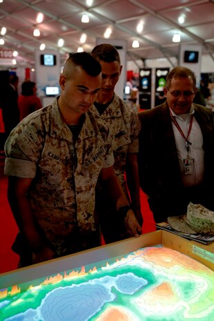 Modern Day Marine attendees look down at the contour map projected onto the sand of the Augmented Reality Sand Table on Marine Corps Base Quantico, Va., on Sept. 23. The ARES combines readily available and relatively inexpensive commercial off-the-shelf technology to make one of the battlefield's oldest technologies like new. 