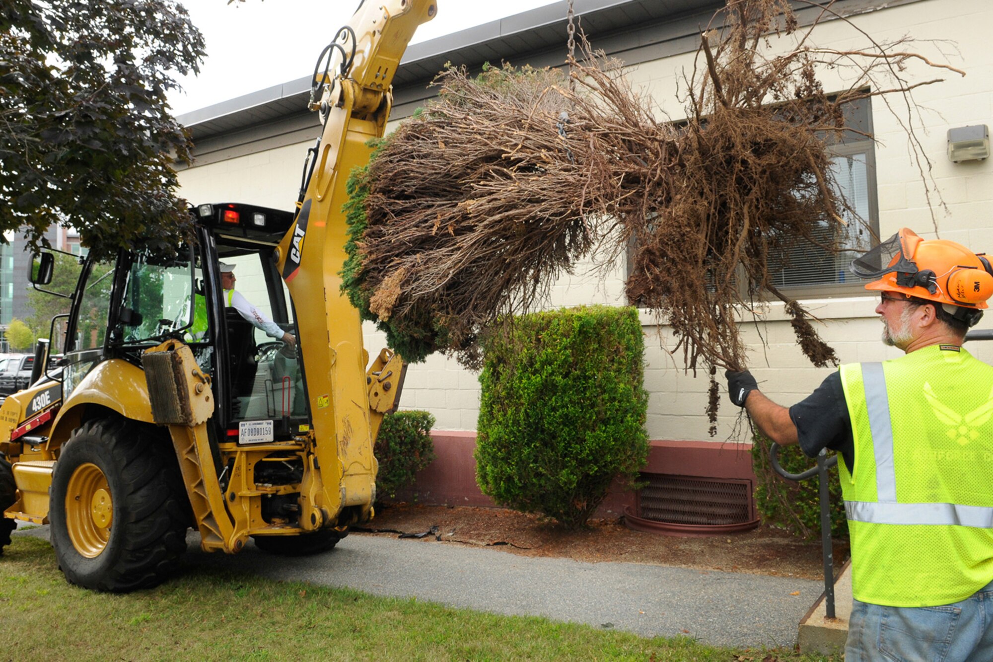 Dennis Cullen and Steve Morris (right), both members of the Civil Engineer Roads and Grounds team, removes one of several bushes outside Building 1508 as part of fall cleanup Sept. 19. The Civil Engineer Roads and Grounds team is responsible for maintaining the base throughout the year. (U.S. Air Force photo by Linda LaBonte Britt)