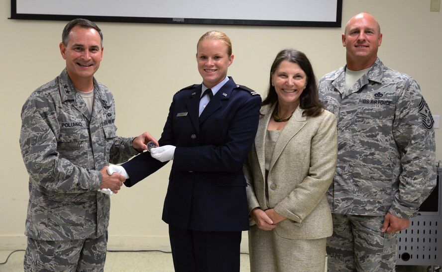 U.S. Air Force Maj. Gen. H.D. Polumbo Jr., Ninth Air Force commander, coins ROTC cadet Kendall Carey for her outstanding physical fitness during the Air Force 67th Birthday ceremony at the University of South Carolina, Columbia, S.C., Sept. 18, 2014. Polumbo spoke with cadets during the ceremony about the importance of being physically fit in the military. (U.S. Air Force photo by Senior Airman Tabatha Zarrella/Released)