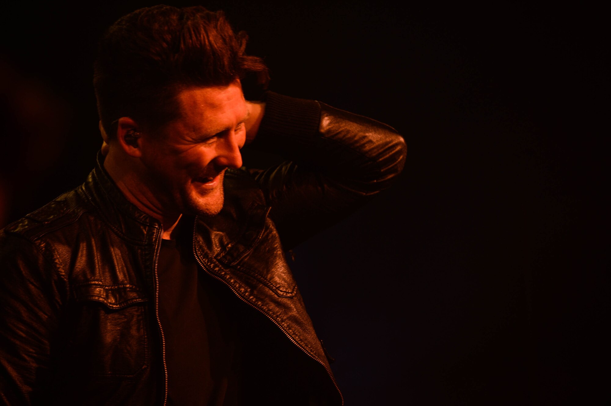 Stephen Christian, a lead vocalist for Anberlin, smiles at the audience during a concert in the Skelton Memorial fitness center at Spangdahelm Air Base, Germany, Sept. 22, 2014. More than 100 people attended the free concert to see one of the band’s last European tour performances. The band plans to disband after their final tour in the United States.  (U.S. Air Force photo by Airman 1st Class Kyle Gese/Released)
