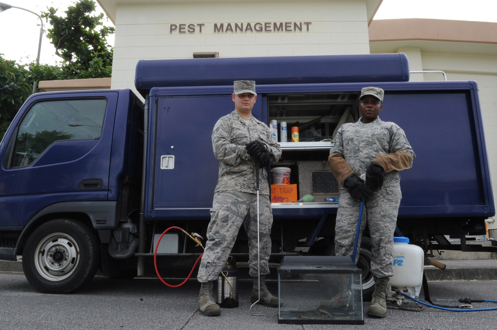 U.S. Air Force Senior Airman Nicholas Stokes, 18th Civil Engineering Squadron pest management journeyman, (left) and Tech. Sgt. Kahlila Mutidi, 18th Civil Engineering Squadron pest management craftsman, pose for a picture outside of their headquarters near the Banyan Tree Golf Course on Kadena Air Base, Japan, Sept. 23, 2014. 18th CES Pest Control is responsible for the eradication, entrapment and protection against any insect, reptilian or small animal pests on Kadena Air Base such as cockroaches, termites, snakes and mongooses. (U.S. Air Force photo by Airman 1st Class Zackary A. Henry/Released)