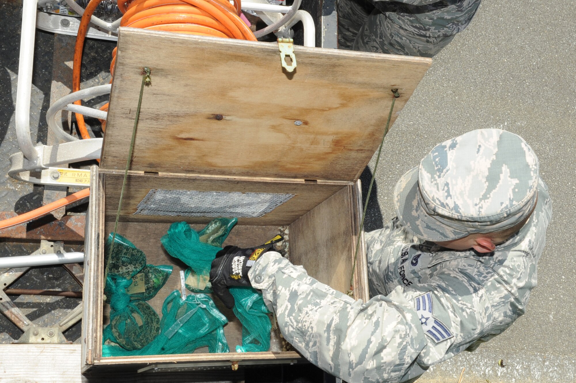 U.S. Air Force Senior Airman Nicholas Stokes, 18th Civil Engineering Squadron pest management journeyman, safely stores the Taiwan Habu snakes for travel from the munitions area back to their headquarters on Kadena Air Base, Japan, Sept. 17, 2014. The Taiwan Habu snakes are trapped and collected to be studied because they are an invasive species. (U.S. Air Force photo by Airman 1st Class Zackary A. Henry/Released)