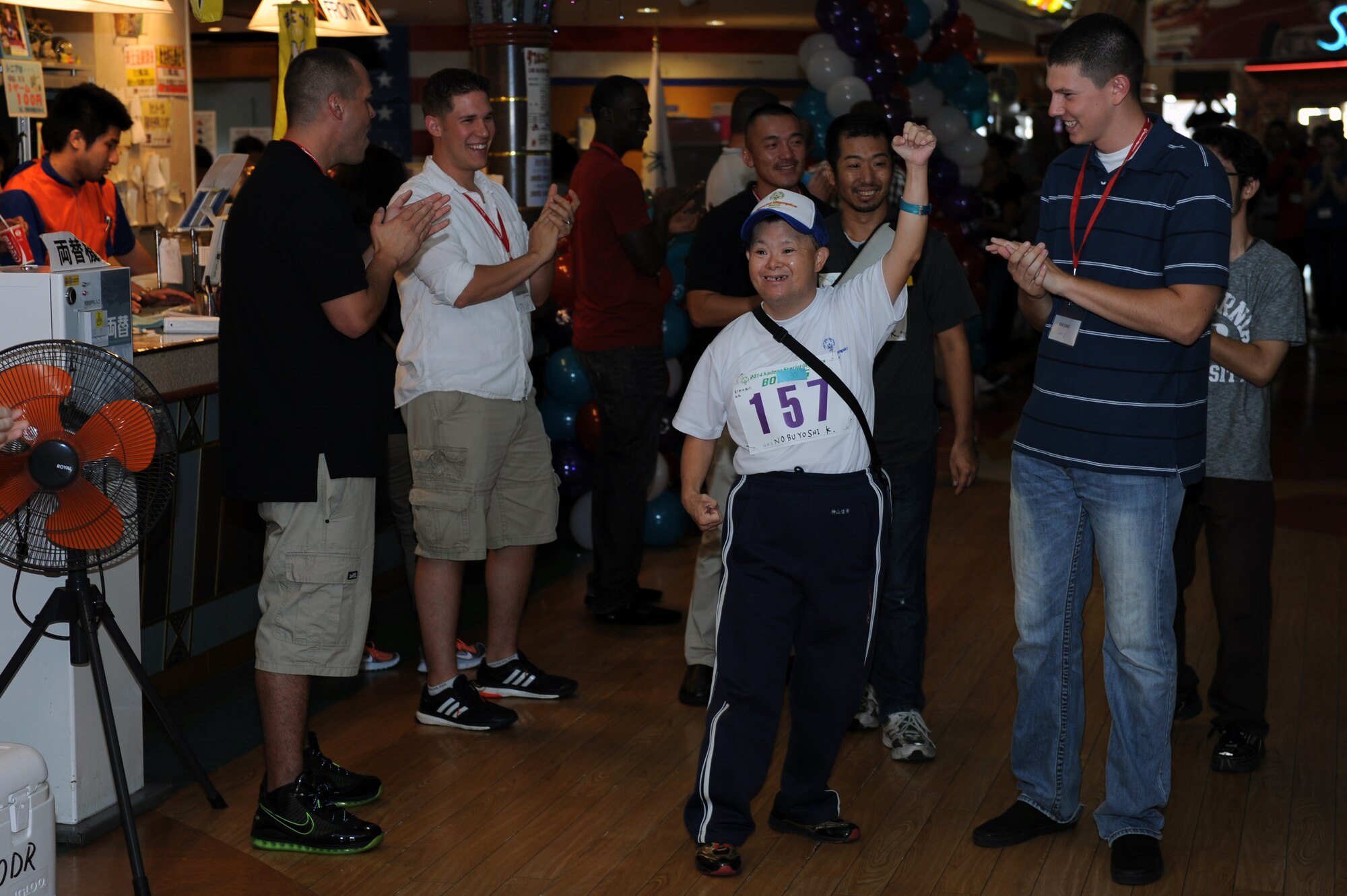 Nobuyoshi Kamiyama, a Special Olympics athlete, raises his fist as volunteers cheer him on at a bowling competition at Seaside Bowl in Mihama, Japan, Sept. 20, 2014. More than 150 Department of Defense volunteers and 50 volunteer interpreters greeted the athletes and supported them throughout the competition. (U.S. Air Force photo by Airman 1st Class Zade C. Vadnais/Released)