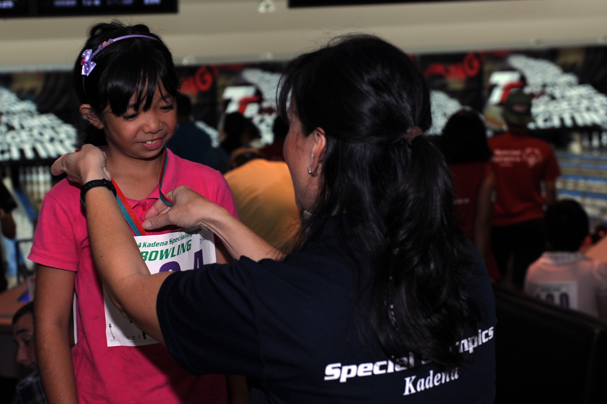 U.S. Air Force Col. Debra Lovette, 18th Mission Support Group commander, presents Hinako Tokeshi, a Special Olympics athlete, with a gold medal during a bowling competition at Seaside Bowl in Mihama, Japan, Sept. 20, 2014. Lovette gave opening remarks for the event and awarded medals along with Toshihisa Takata, Ministry of Foreign Affairs of Japan ambassador in charge of Okinawan affairs, and other distinguished guests. (U.S. Air Force photo by Airman 1st Class Zade C. Vadnais/Released)