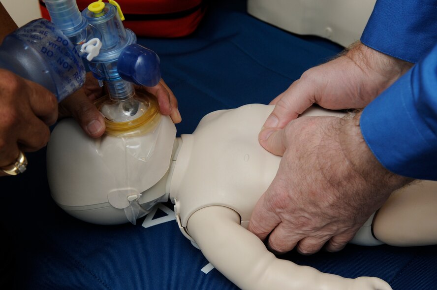 U.S. Air Force medical practitioners practice a two-person CPR technique on a baby simulator on Kadena Air Base, Japan Sept. 19, 2014. The training is part of health care providers’ basic life saving skills, aerovac medics’ skills and a requirement for Emergency Medical Technicians. (U.S. Air Force photo by Senior Airman Marcus Morris/Released)